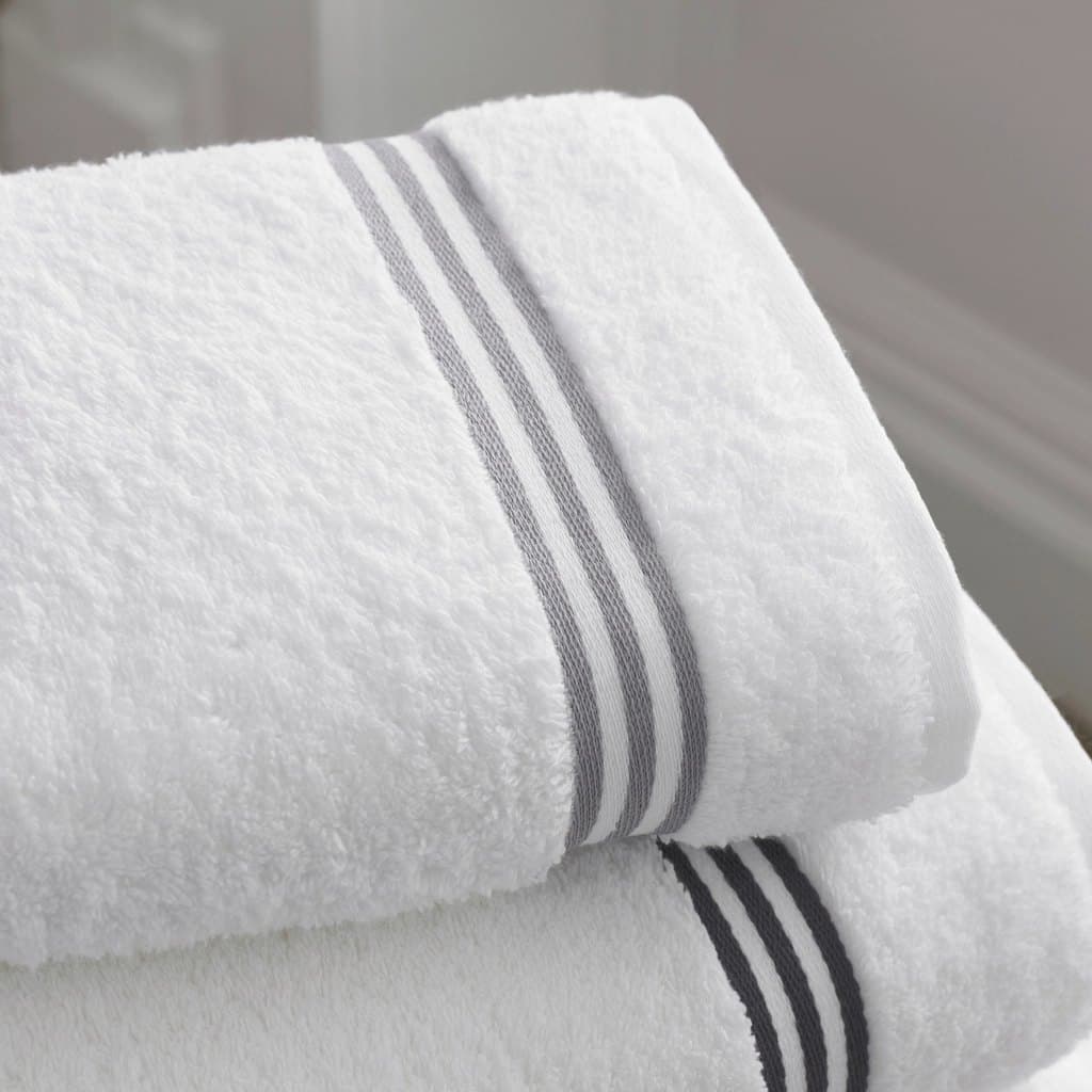 Folded white cotton bath towels with grey stripe borders