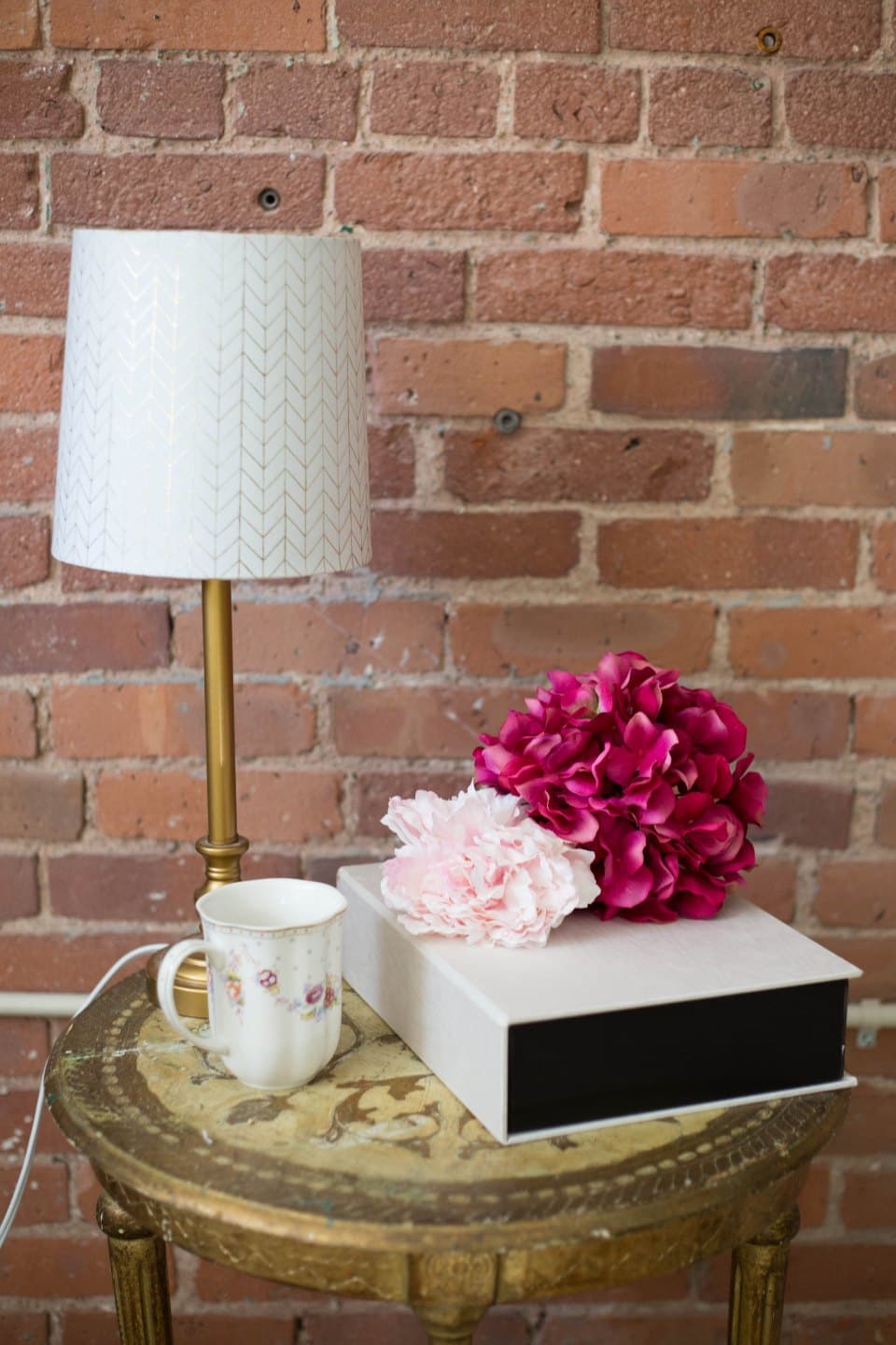 Brass table lamp with a patterned fabric shade on a side table