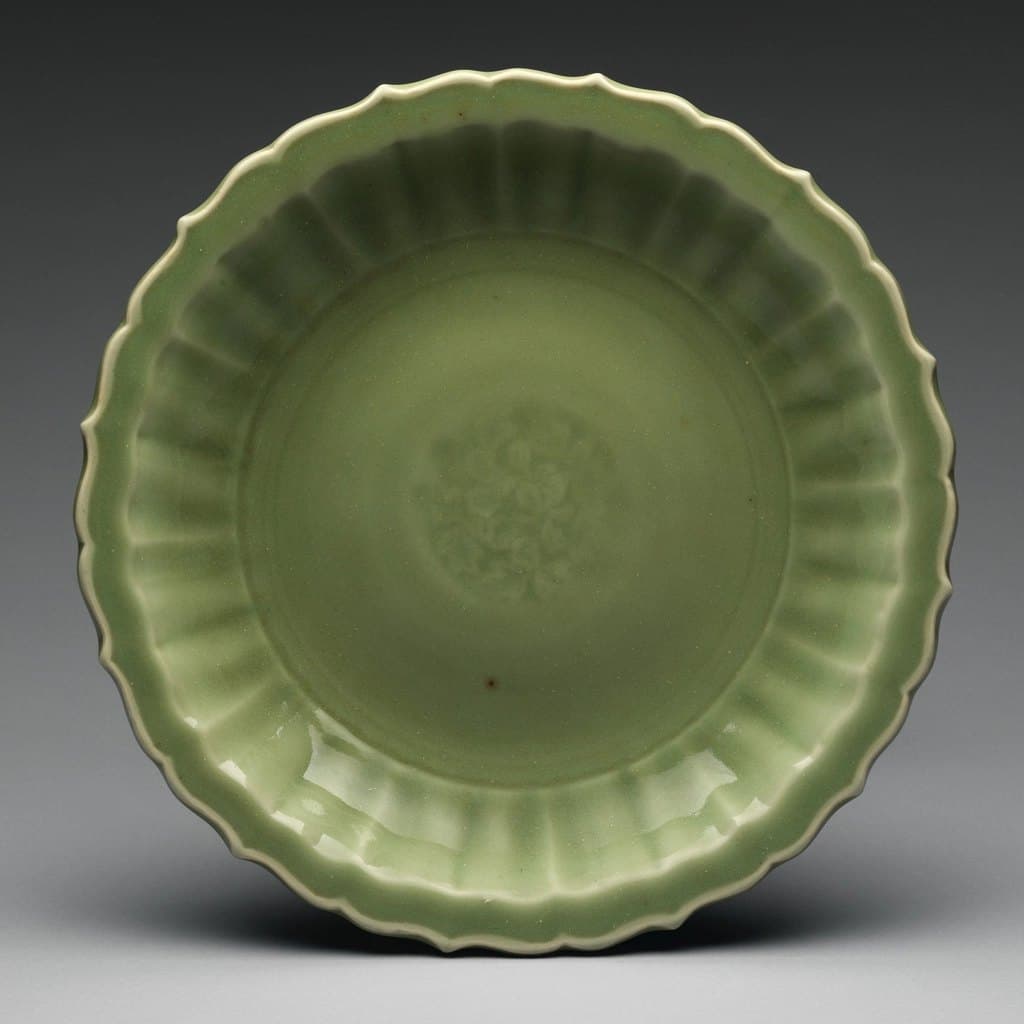 Fluted celadon ceramic dish with a scalloped rim and a pale sage glaze