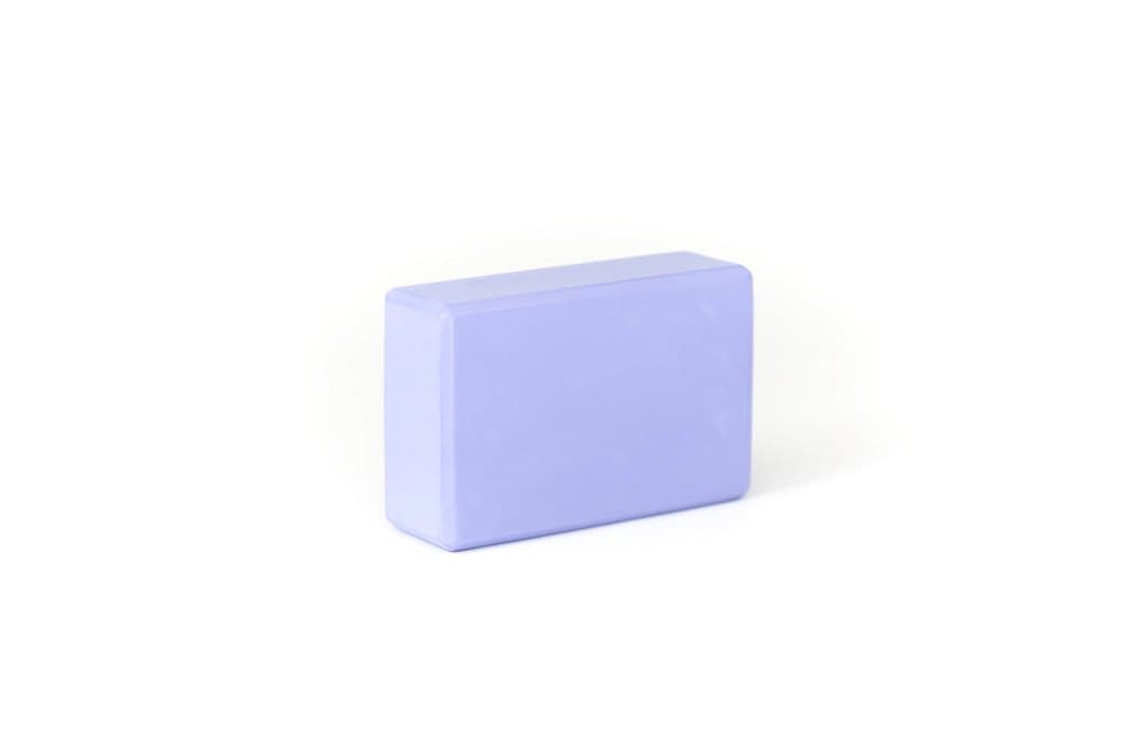 Lilac EVA foam yoga block on a white studio surface