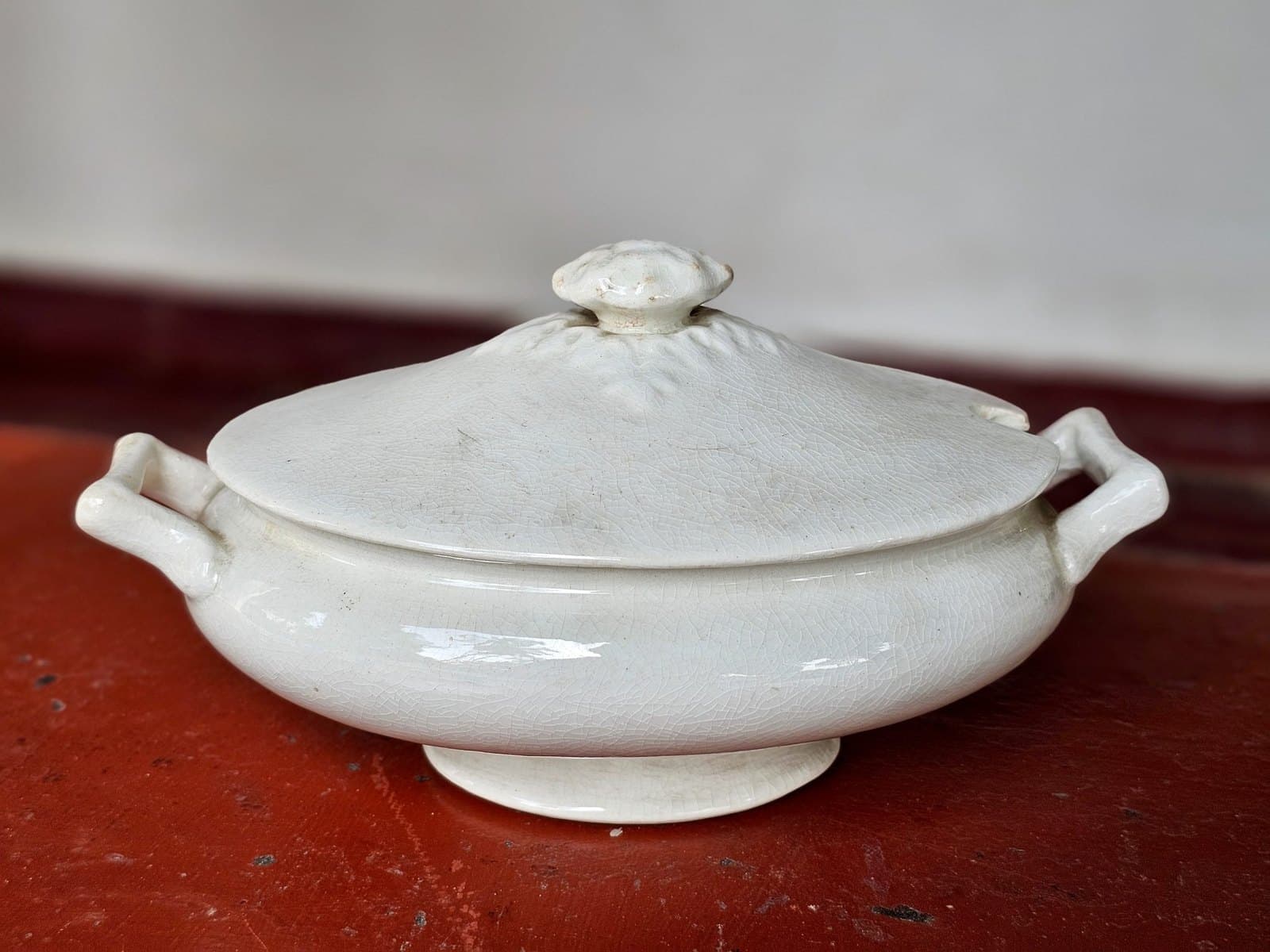 White ceramic tureen with lid, side handles, and a crackle glaze