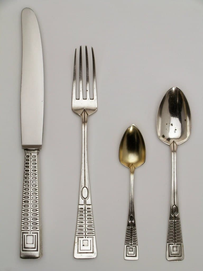 Matte stainless steel flatware arranged on linen