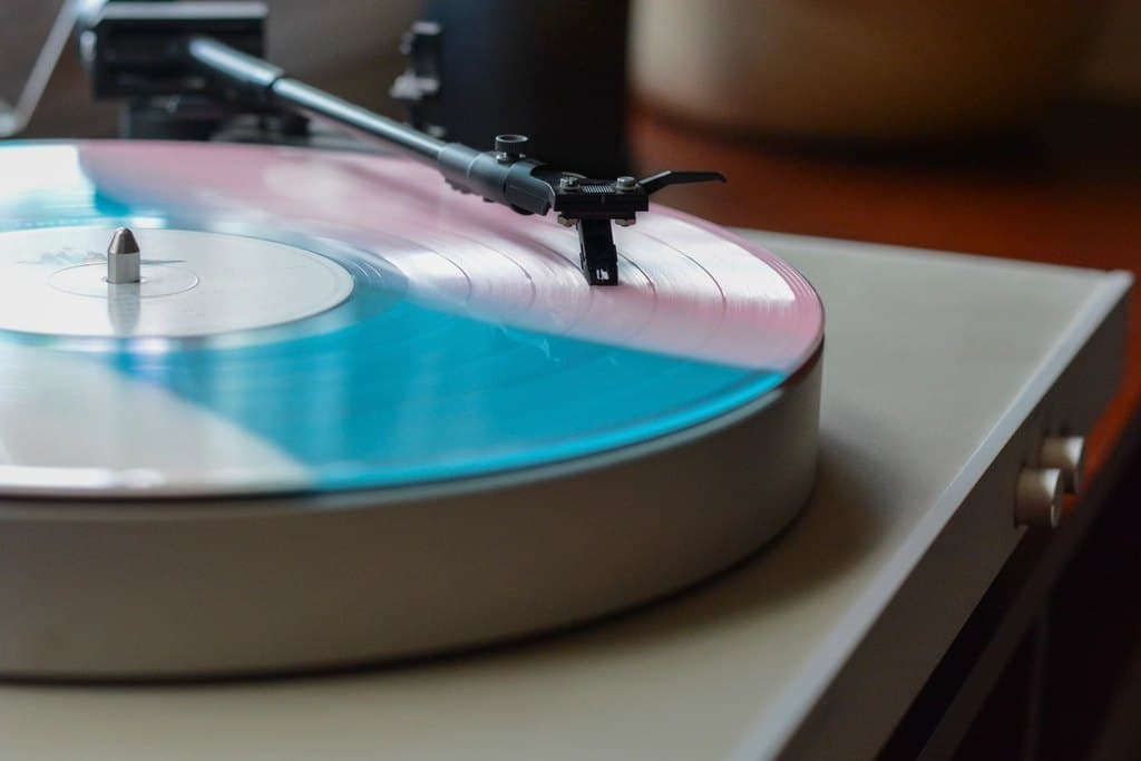 Belt-drive record player with a light plinth playing a vinyl record